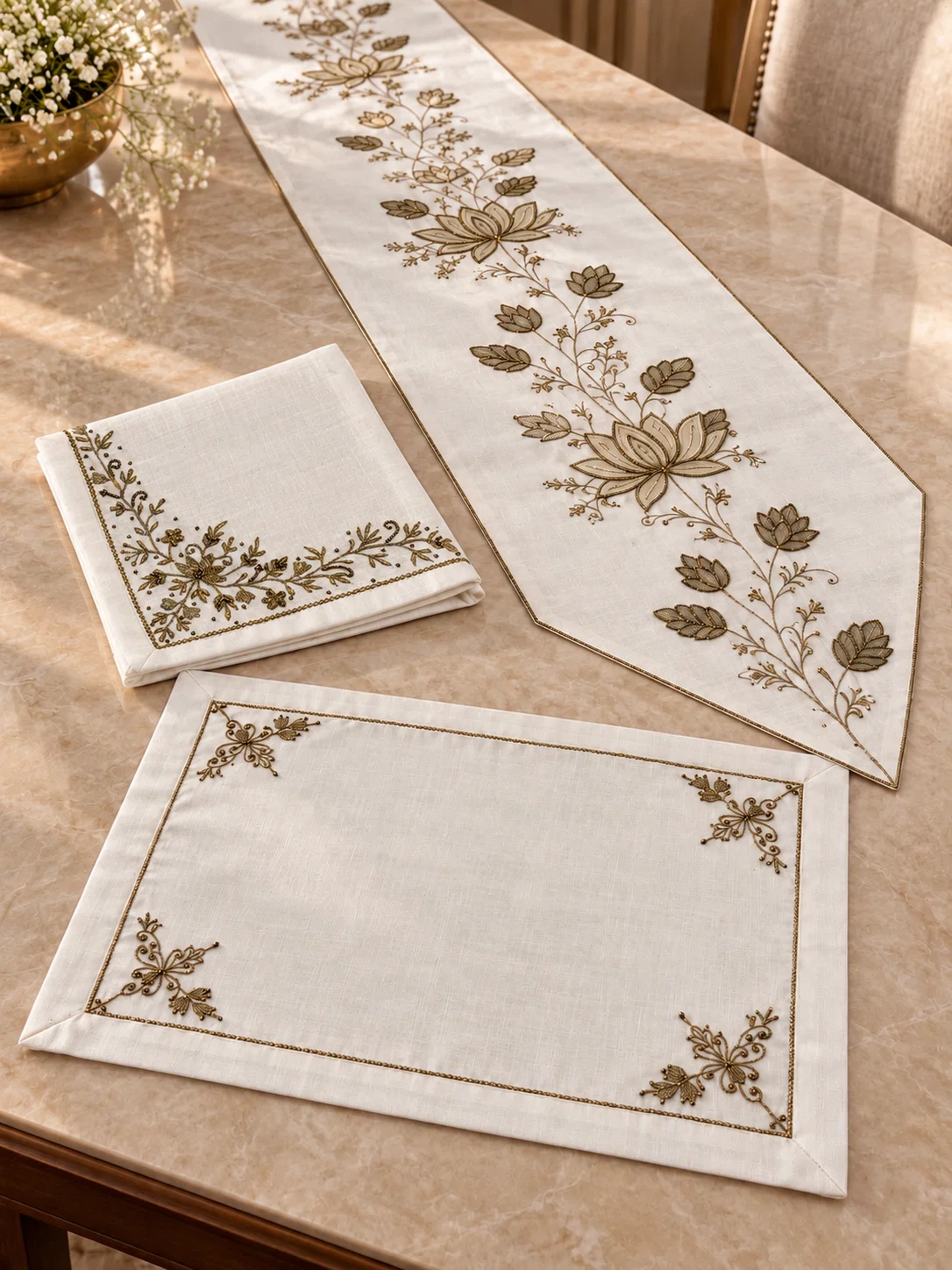 make-your-table-feel-thoughtfully-dressed-with-ivory-linens-graceful-lotus-embroidery-and-warm-antique-gold-accents-this-coordinated-nine-piece-set-brings-together-a-runner-four-placemats-and-four